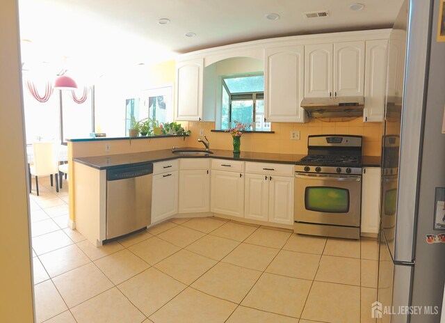 8 Carlisle Ct, Old Bridge, NJ 08857 - kitchen featuring appliances with stainless steel finishes, under cabinet range hood, dark countertops, light tile patterned flooring, and white cabinets