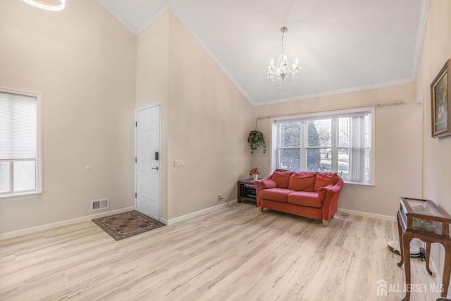 entrance foyer featuring wood finished floors, visible vents, baseboards, a chandelier, and ornamental molding