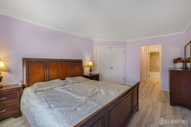 bedroom with ornamental molding, light wood-style flooring, a closet, and baseboards