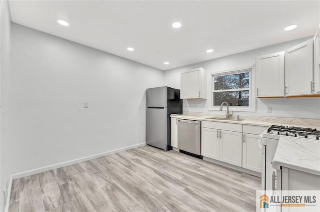 440 E Ave, Sewaren, NJ 07077 - kitchen with stainless steel appliances, recessed lighting, light stone counters, white cabinets, and light wood finished floors