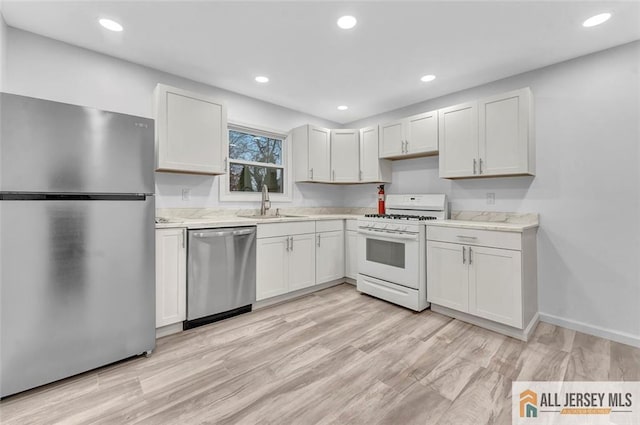 440 E Ave, Sewaren, NJ 07077 - kitchen with appliances with stainless steel finishes, light countertops, recessed lighting, white cabinets, and light wood finished floors