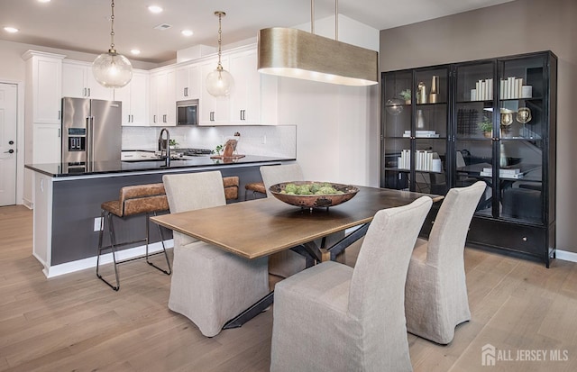 dining space with light hardwood / wood-style flooring and sink