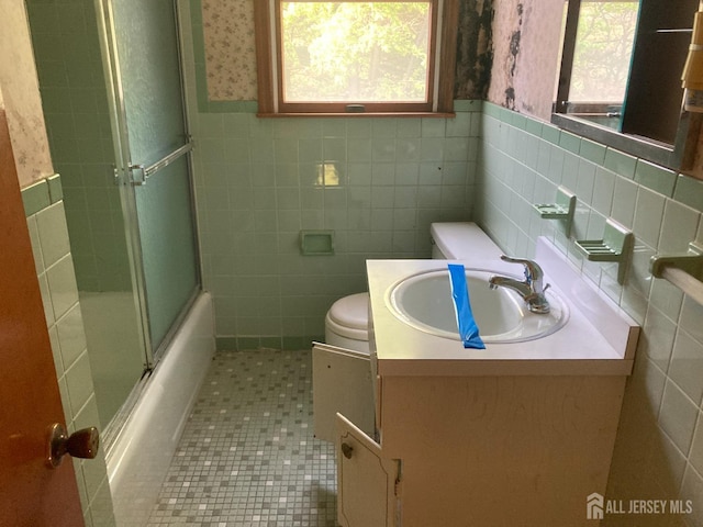 bathroom featuring wainscoting, toilet, and wallpapered walls