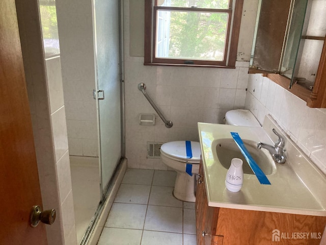 full bath with vanity, toilet, tile patterned floors, tile walls, and a stall shower