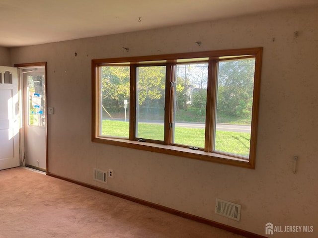 carpeted entrance foyer featuring baseboards and visible vents