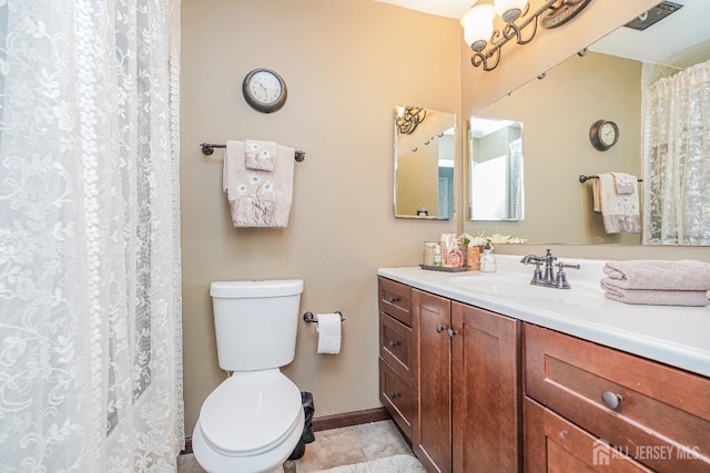 bathroom featuring baseboards, vanity, toilet, and tile patterned floors