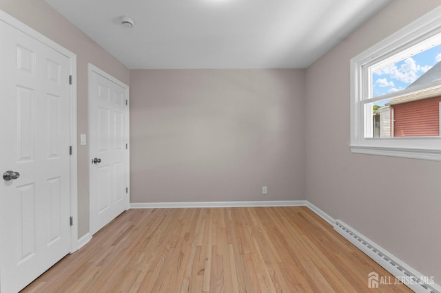 226 Schussler St, Sayreville, NJ 08879 - spare room featuring a baseboard heating unit, light wood-style floors, and a smoke detector