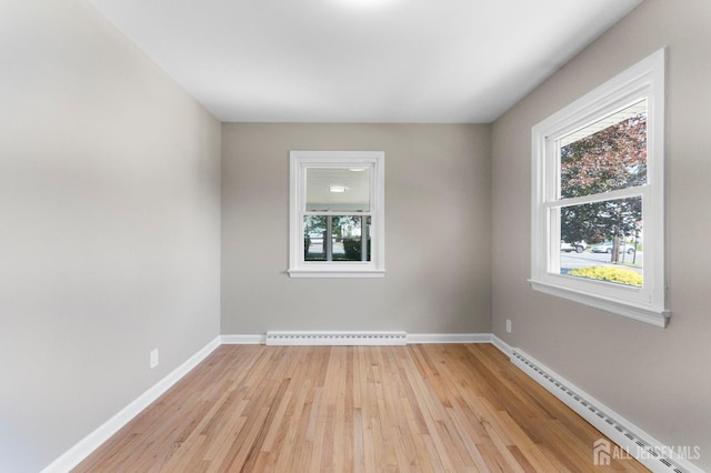 226 Schussler St, Sayreville, NJ 08879 - empty room featuring baseboard heating, light wood-style floors, and a baseboard radiator