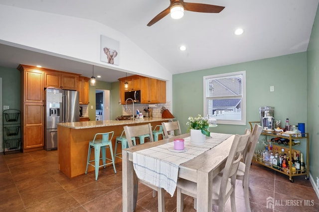 dining space with vaulted ceiling, a ceiling fan, recessed lighting, and dark tile patterned flooring