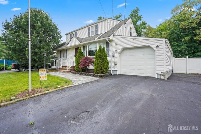 view of front of house featuring an attached garage, asphalt driveway, and a shingled roof