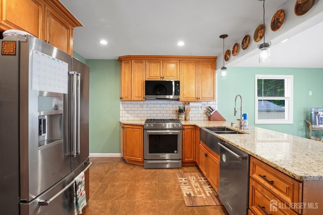 kitchen with stainless steel appliances, a sink, a peninsula, tasteful backsplash, and brown cabinetry