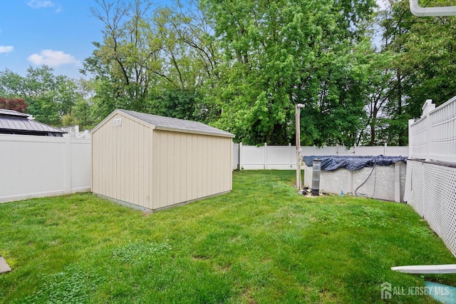view of yard with a shed, an outbuilding, and view of wooded area