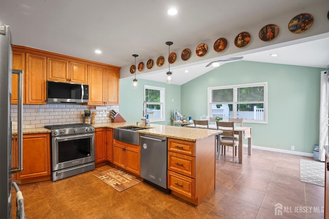 kitchen featuring stainless steel appliances, a sink, a peninsula, lofted ceiling, and brown cabinets