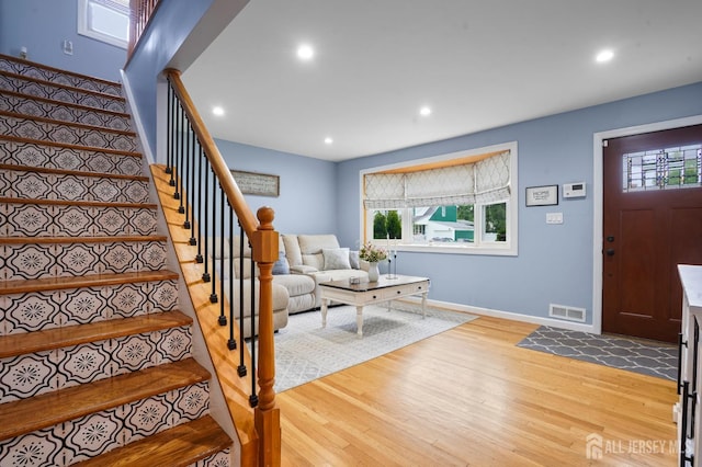 entrance foyer featuring light wood finished floors, recessed lighting, stairs, and baseboards