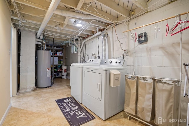 clothes washing area featuring gas water heater and washer and clothes dryer