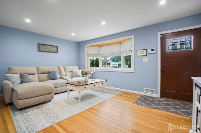living room featuring light wood-type flooring, baseboards, and recessed lighting
