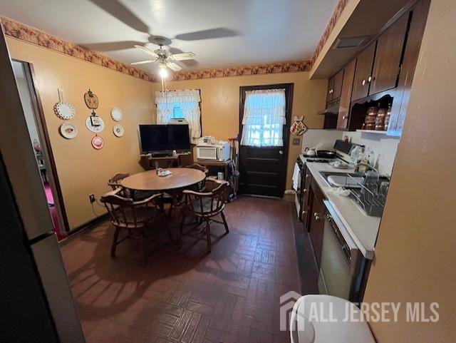 1436 Thomas Ave, North Brunswick, NJ 08902 - kitchen with a sink, a ceiling fan, dark brown cabinets, under cabinet range hood, and gas stove