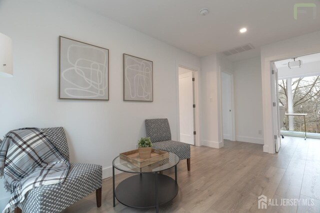 sitting room featuring baseboards, recessed lighting, visible vents, and light wood-style floors