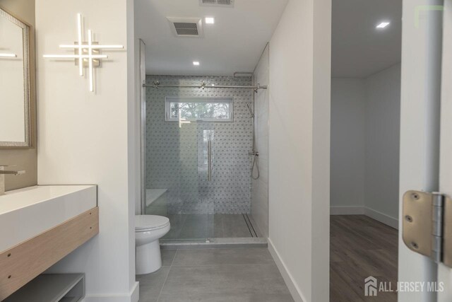 full bathroom featuring toilet, visible vents, and a walk in shower