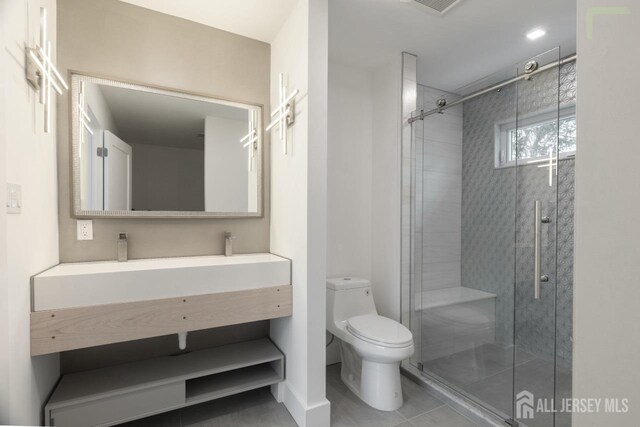 bathroom with vanity, tile patterned flooring, a shower stall, and toilet