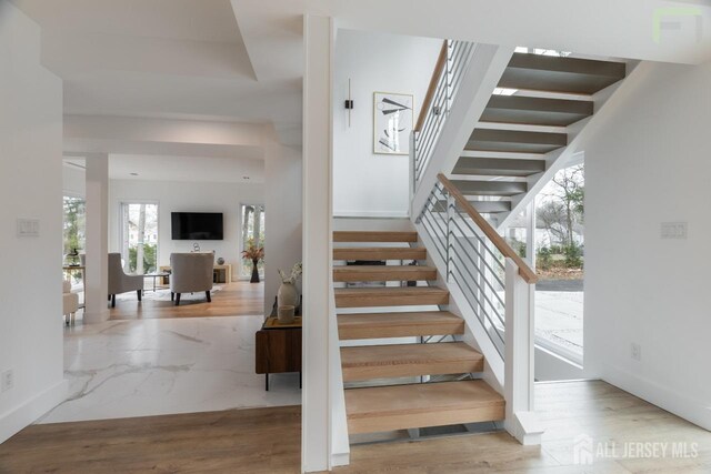 staircase featuring wood finished floors and baseboards