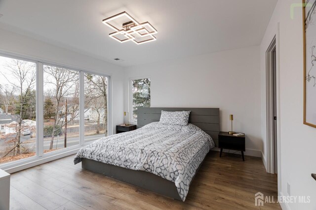 bedroom with baseboards and wood finished floors