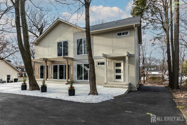 view of front of home with roof with shingles and stucco siding