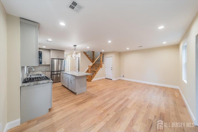 17 Fourth St, Hillsborough, NJ 08821 - kitchen with freestanding refrigerator, gray cabinetry, a sink, a kitchen island, and light wood-style flooring