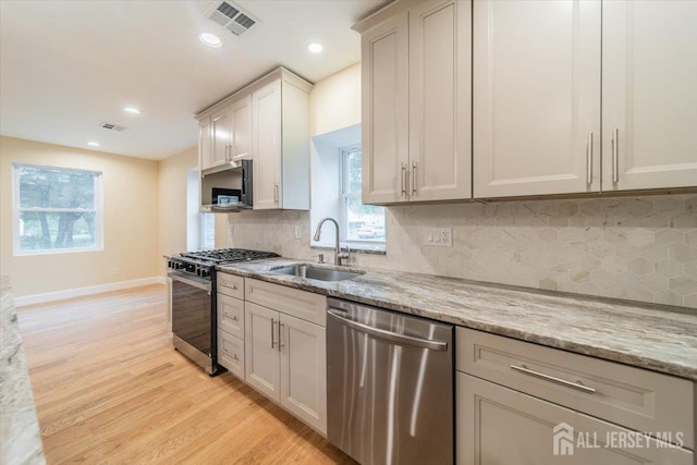 17 Fourth St, Hillsborough, NJ 08821 - kitchen featuring stainless steel appliances, a sink, light wood-style flooring, light stone countertops, and recessed lighting