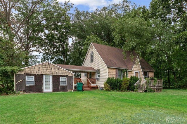 rear view of property with a yard and a wooden deck