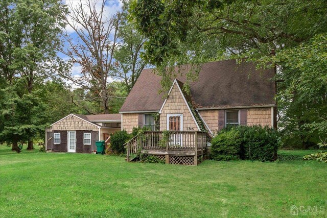 back of property with a yard and a wooden deck