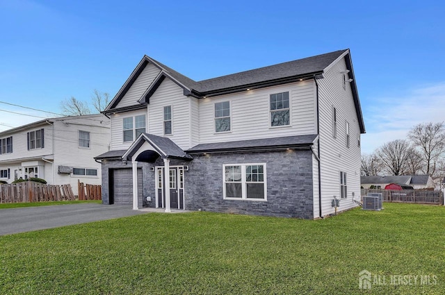 front facade with a front lawn, a garage, and central AC