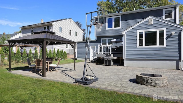 back of property with a gazebo, a patio, a fire pit, and fence