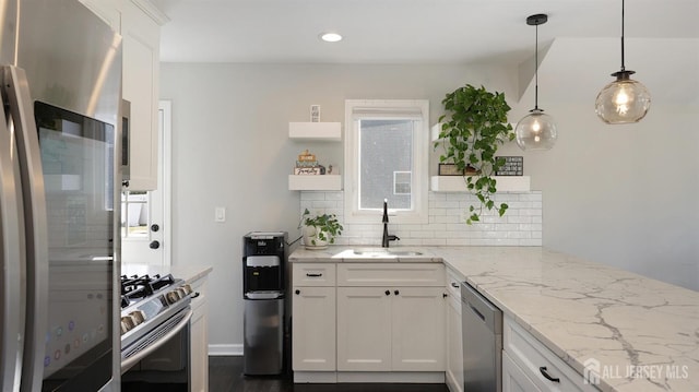 kitchen featuring a sink, open shelves, light stone counters, backsplash, and appliances with stainless steel finishes