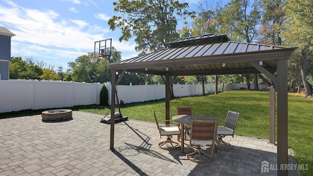 view of patio featuring a gazebo, outdoor dining area, a fire pit, and a fenced backyard