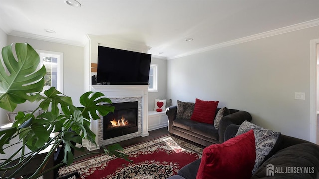 living room featuring a wealth of natural light, wood finished floors, ornamental molding, and a fireplace