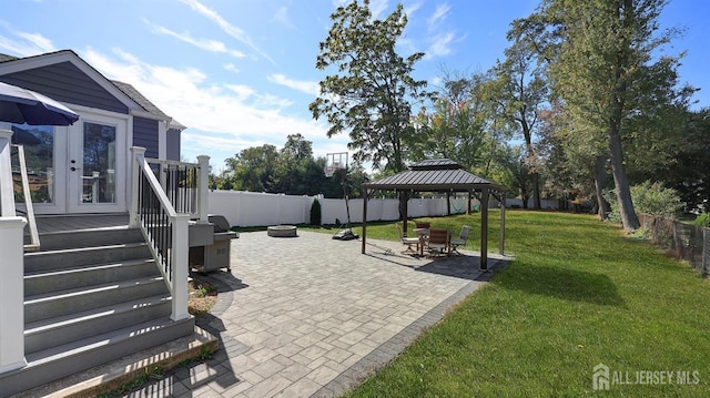 view of patio / terrace featuring a gazebo, french doors, a fire pit, and a fenced backyard