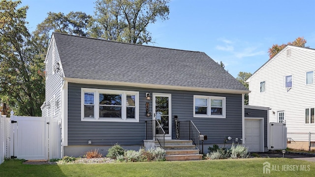 cape cod-style house featuring fence, a shingled roof, a front lawn, and a gate