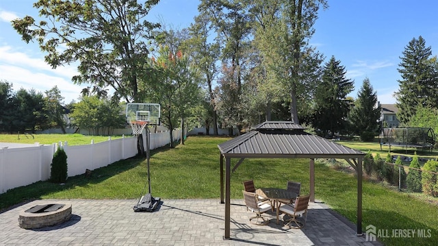 view of patio / terrace featuring a fenced backyard, a fire pit, a gazebo, and a trampoline