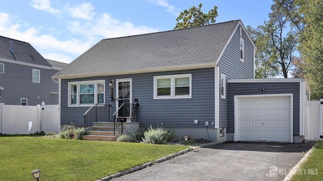 view of front of home with a shingled roof, fence, aphalt driveway, a front yard, and a garage