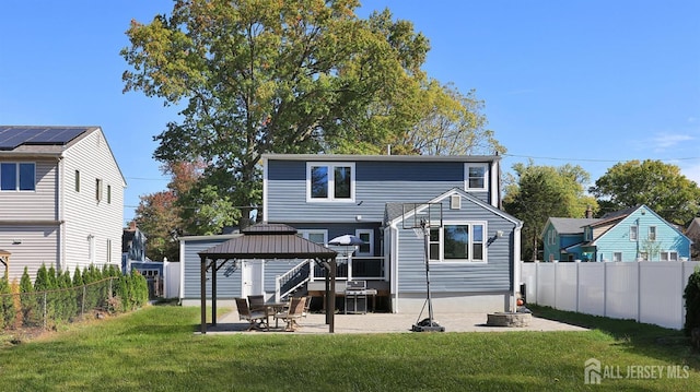 rear view of property with a gazebo, a fenced backyard, a lawn, and a patio