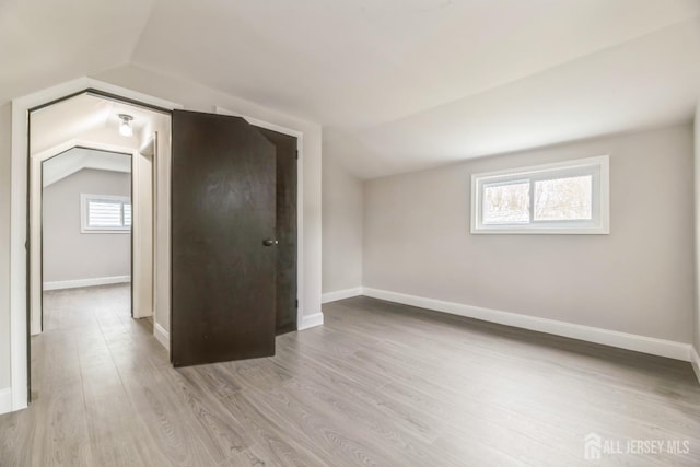 bonus room with lofted ceiling, baseboards, and wood finished floors