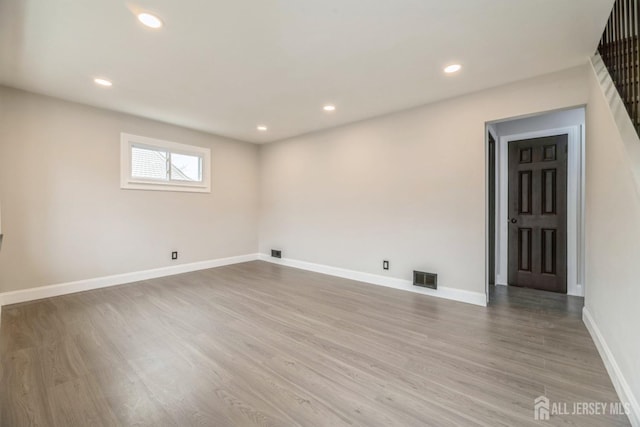 spare room with baseboards, recessed lighting, visible vents, and wood finished floors