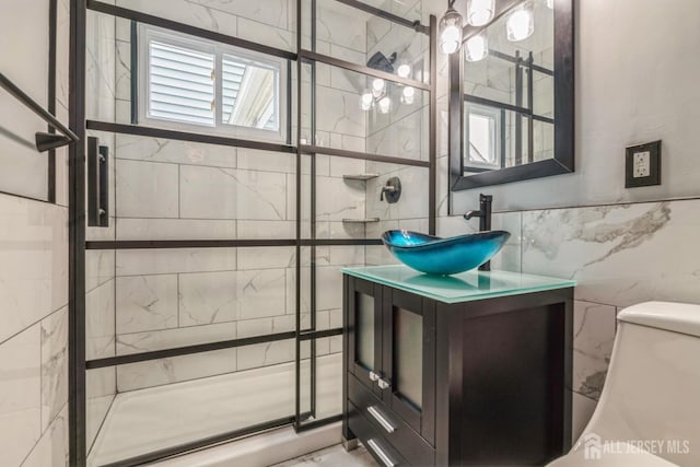 full bathroom featuring toilet, tile walls, vanity, and a stall shower