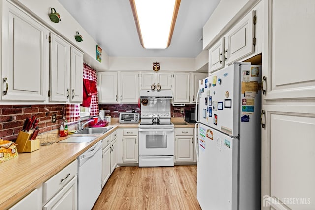 kitchen featuring light wood-style flooring, white appliances, light countertops, and a sink