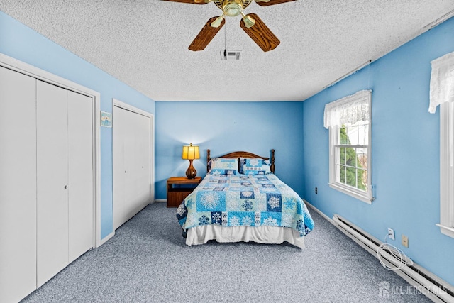 carpeted bedroom with visible vents, a textured ceiling, a baseboard radiator, baseboards, and ceiling fan