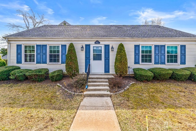 view of front of property featuring a shingled roof and a front lawn