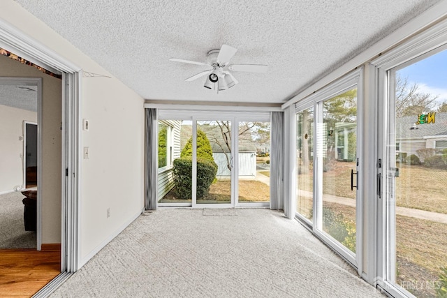 unfurnished sunroom with a ceiling fan