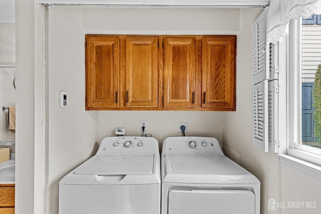 washroom featuring cabinet space and separate washer and dryer