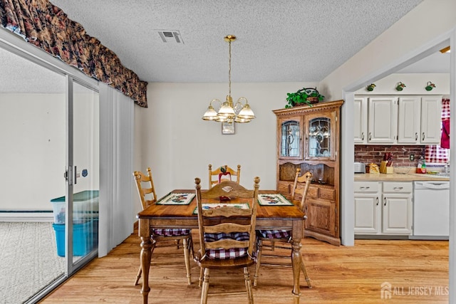 dining space with a chandelier, visible vents, a baseboard heating unit, and light wood-type flooring